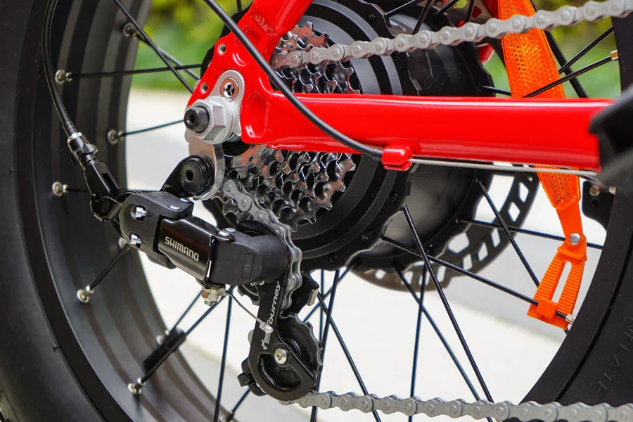 Compact Folding red fat-tire electric bike on outdoor display — side view